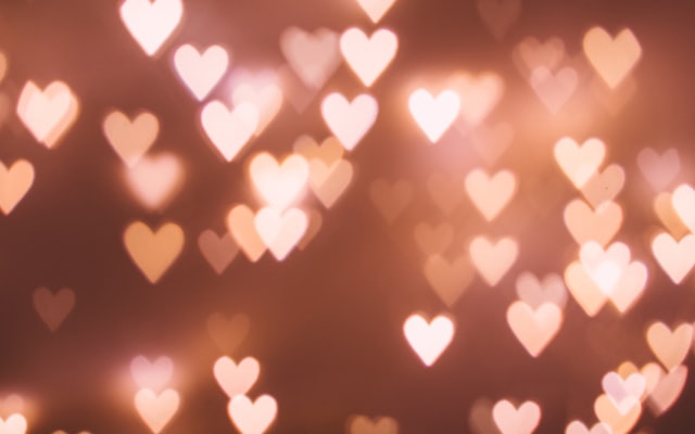 Cœurs lumineux en bokeh évoquant la complicité amoureuse
