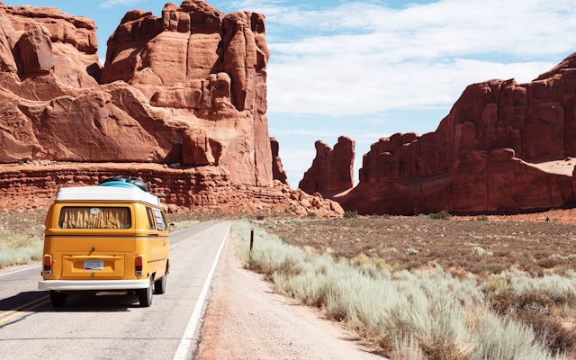 Van jaune sur une route de road-trip, symbole des rêves de couple à réaliser